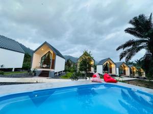 a pool in front of a group of houses at Khaosok Sunset Resort in Khao Sok National Park