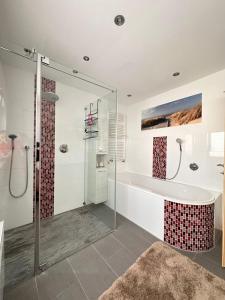 un baño con bañera y ducha de cristal en SK Apartments -Apartment mit 2 Schlafzimmern, en Rust