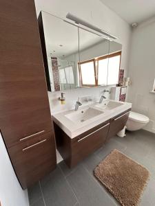 Un baño con lavabo, espejo e inodoro. en SK Apartments -Apartment mit 2 Schlafzimmern, en Rust 41 fotos más