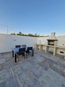 a patio with a table and chairs and a grill at Casa Vacanze - Uliveto in Sciacca