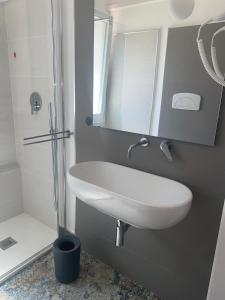 a bathroom with a white sink and a shower at Dimora del Salento Apartment in Brindisi