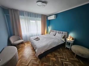 a bedroom with a bed and a blue wall at Apartment Home in Troyan