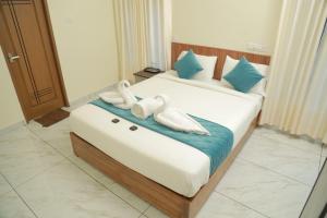 dos animales de peluche sentados en una cama en una habitación de hotel en Palm Paradise Beach Resort Varkala, en Varkala