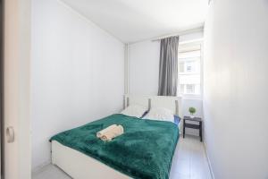 a small bedroom with a bed with a green blanket at Sunhill Luxury apartman at Buda Castle in Budapest