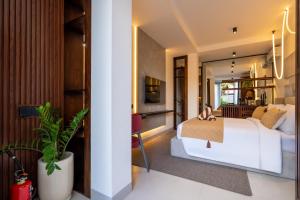 een slaapkamer met een wit bed en een woonkamer bij Palermo Suites by Betterplace in Ubud