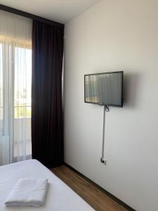 Un dormitorio con una cama con un televisor en la pared. en DUMAR Apartament, en Mamaia 4 fotos más