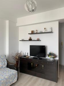 Una sala de estar con televisión y un sofá. en DUMAR Apartament, en Mamaia
