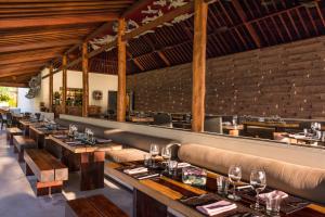 a restaurant with a long row of tables and chairs at Qunci Villas Resort in Senggigi