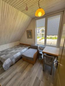 a bedroom with a bed and a desk and a table at Gintaro Vila in Kunigiškiai