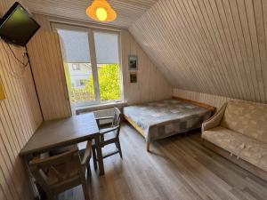 a room with a bed and a table and a couch at Gintaro Vila in Kunigiškiai