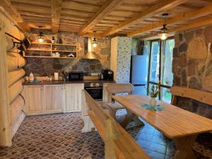 a kitchen with a wooden table and a kitchen with a refrigerator at Gintaro Vila in Kunigiškiai