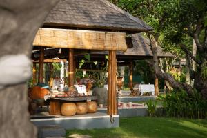 a gazebo with a table in a garden at Qunci Villas Resort in Senggigi