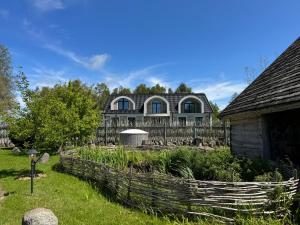 a large house with a fence and a garden at Gintaro Vila in Kunigiškiai