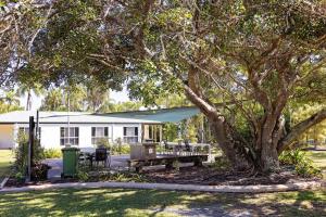 a house with a picnic table and a tree at The Shores Holiday Apartments in Mackay