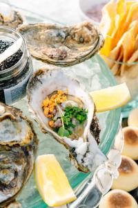 a bunch of oysters on a glass plate with a lemon at Qunci Villas Resort in Senggigi