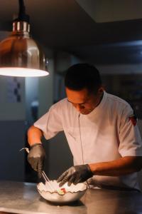 a man preparing food in a bowl in a kitchen at Qunci Villas Resort in Senggigi