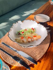 a plate of food on a wooden table with a plate of food at Qunci Villas Resort in Senggigi