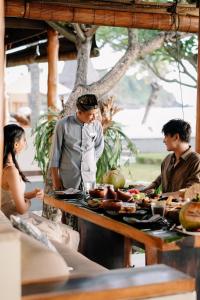 a group of people standing around a table with food at Qunci Villas Resort in Senggigi