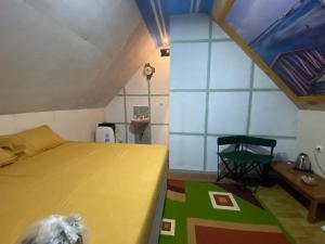 a bedroom with a bed and a table and a chair at Kabin Sahara in Pulau Tidung-kecil