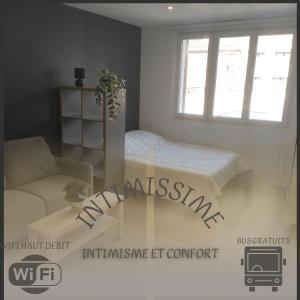 Habitación con cama, sofá y ventana en Intimissime, en Dunkerque