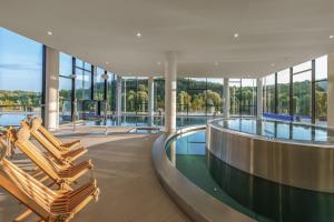 ein Gebäude mit Pool und Liegestühlen in der Unterkunft Hotel Essence in Pogány