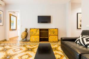 a living room with a couch and a tv at Provenza Flat in Barcelona