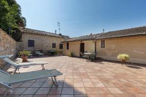 a patio with chairs and tables in a courtyard at Casa Vacanze Etrusco in San Gimignano
