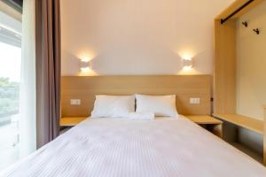 a bedroom with a white bed with two pillows at SithoniaRS White Sand Luxury Maisonette in Neos Marmaras