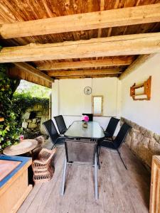 eine Terrasse mit einem Tisch, Stühlen und einem Kamin in der Unterkunft Podkroví v pošumavské chalupě in Pačejov