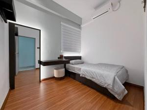 a bedroom with a bed and a desk and a mirror at Sri Indah Premium in Sandakan
