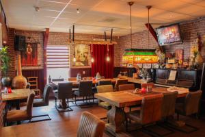 a dining room with tables and chairs and brick walls at Hotel,cafe,biljart POT in Groenlo