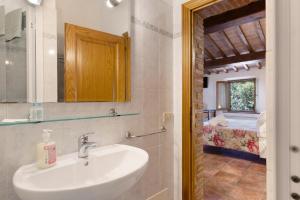 a bathroom with a sink and a mirror and a bedroom at Casa Vacanze Etrusco in San Gimignano +36 photos