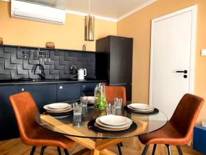 a kitchen with a table with chairs and a black counter at Biała mewa in Huta