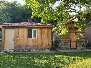 a wooden cabin with a door in a yard at Sunset Krikhi in Ambrolauri