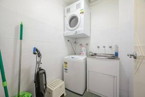 a small kitchen with a washing machine and a sink at Burwood 2Br Apt Near Chiantown Shopping Center in Sydney