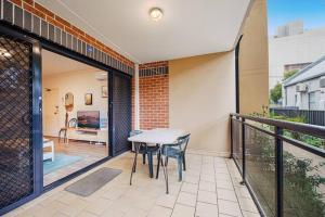 a patio with a table and chairs on a balcony at Burwood 2Br Apt Near Chiantown Shopping Center in Sydney +10 photos