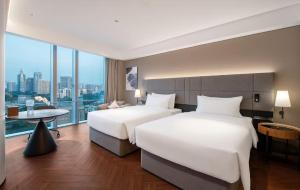 Voodi või voodid majutusasutuse Intercity Hotel Futian Bin He Zhongzhou Bay toas
