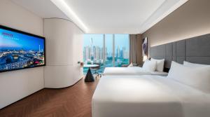 Voodi või voodid majutusasutuse Intercity Hotel Futian Bin He Zhongzhou Bay toas