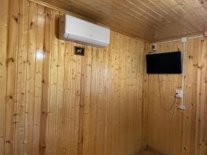 a room with wood paneled walls and a television at Sunset Krikhi in Ambrolauri