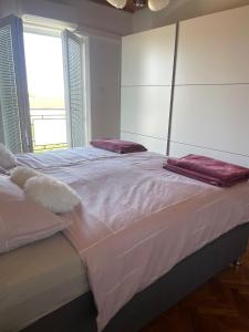 a large bed with two pillows on top of it at Apartment " So" in Senj