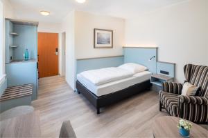 a bedroom with a bed and a living room at Hotel an der Schlei Garni in Fahrdorf