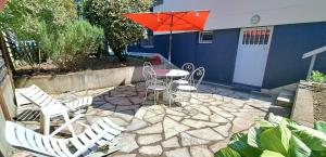 Un patio con una mesa y sillas y una sombrilla. en LA Grâce d'Amboise, en Amboise