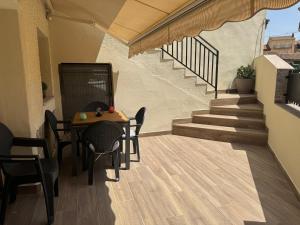 a balcony with a table and chairs and stairs at La casa de las especias in El Barraco