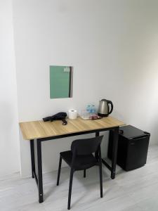 Bangkok NoiGO INN Siriraj BKK โกอินน์ ศิริราช的一张木桌,旁边是椅子 更多37张照片