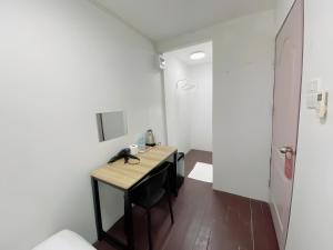 Bangkok NoiGO INN Siriraj BKK โกอินน์ ศิริราช的一间带桌子和电话的小房间