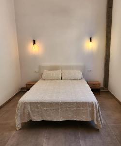 a bed in a room with two lights on the wall at Espectacular Estudio muy grande in Valdemoro +1 photo