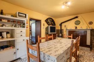 Un comedor con mesa y sillas y un televisor. en Casa Rosa, en Ruota