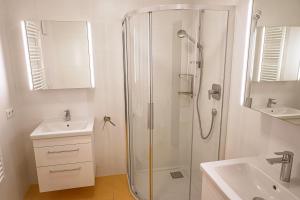 a white bathroom with a shower and a sink at Bischöfliches Institut Vinzentinum in Bressanone