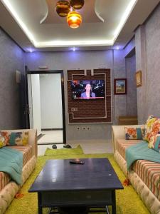 a living room with two couches and a tv at Sunrise Private Apartment in Marrakech
