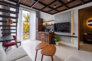 a living room with a television and a table at Palermo Suites Ubud in Ubud